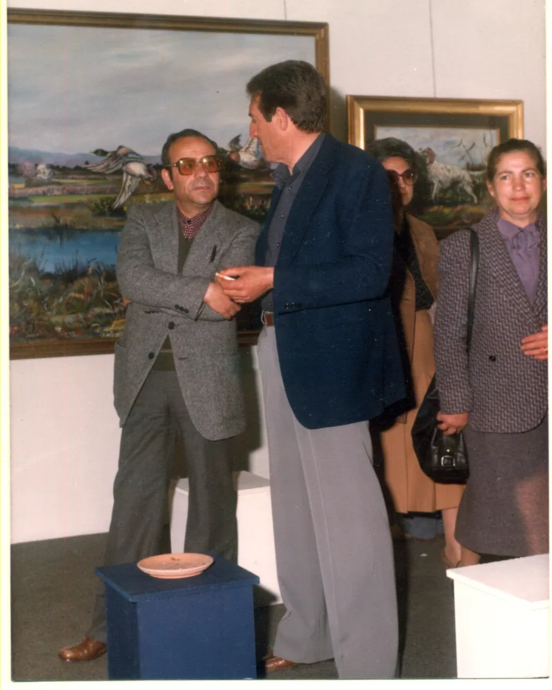 Foto d'epoca: visitatori in conversazione davanti ai quadri