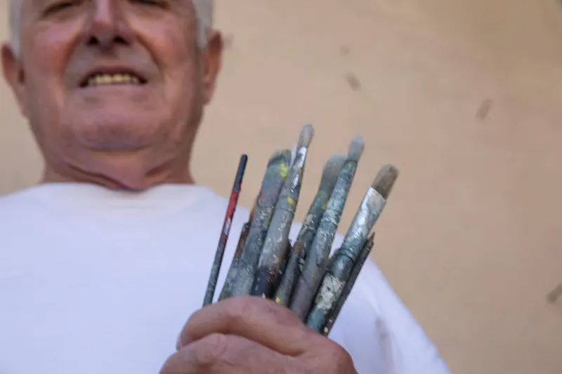 Un mazzo di pennelli consumati in mano ad Aldo